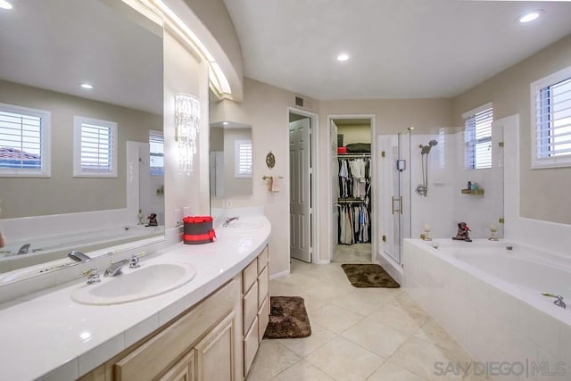 bathroom featuring independent shower and bath, vanity, and tile patterned flooring