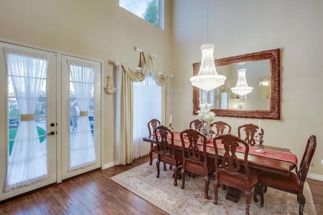 dining area with hardwood / wood-style floors, french doors, and a high ceiling