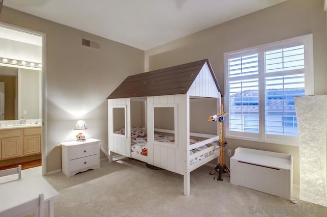 carpeted bedroom featuring ensuite bathroom