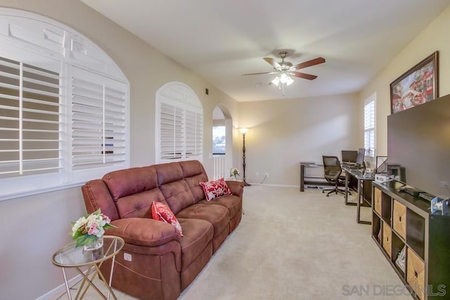 carpeted living room with ceiling fan