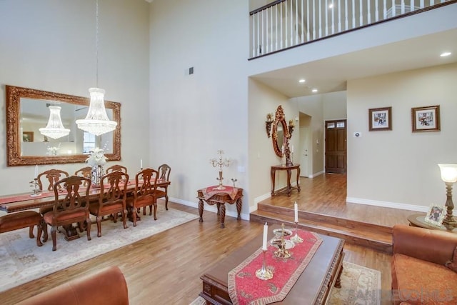 living room with a chandelier, hardwood / wood-style floors, and a high ceiling