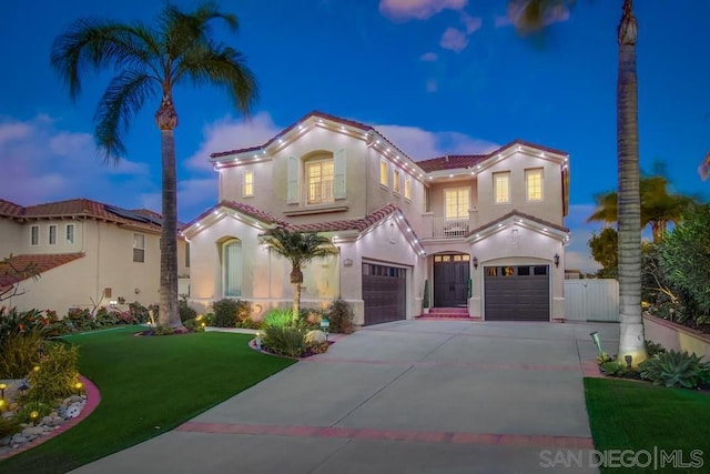 mediterranean / spanish house featuring a garage and a lawn