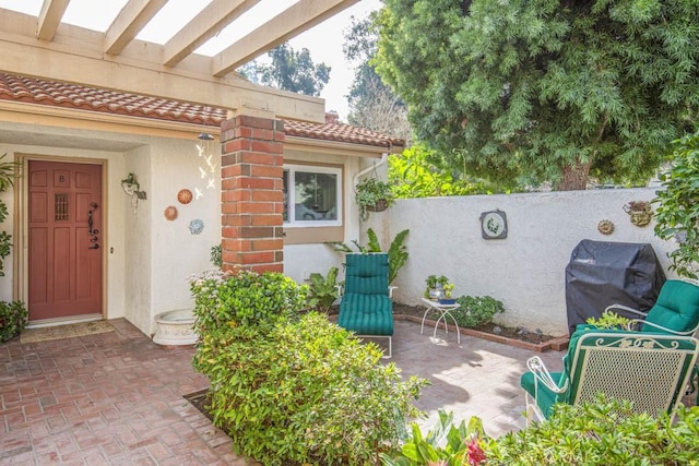 view of patio with grilling area and a pergola