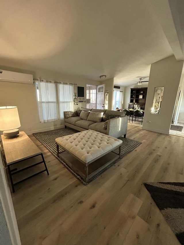 living room featuring hardwood / wood-style flooring and an AC wall unit