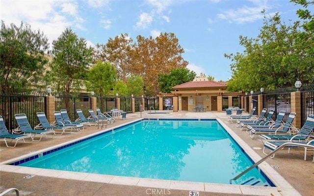 pool with fence and a patio