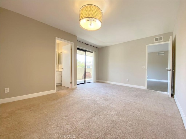 unfurnished room with light colored carpet, visible vents, and baseboards