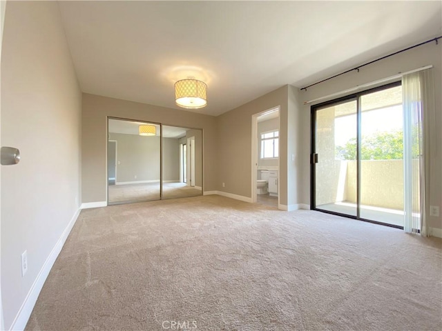 empty room with a healthy amount of sunlight, carpet, and baseboards