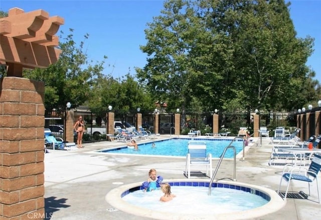 pool with a patio and fence