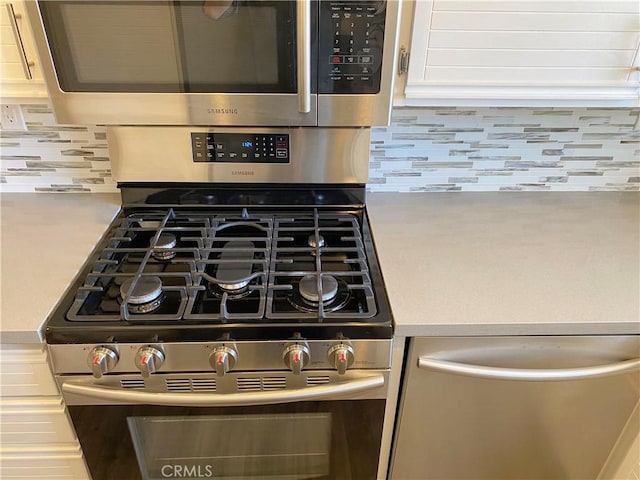 room details with stainless steel appliances, light countertops, and tasteful backsplash