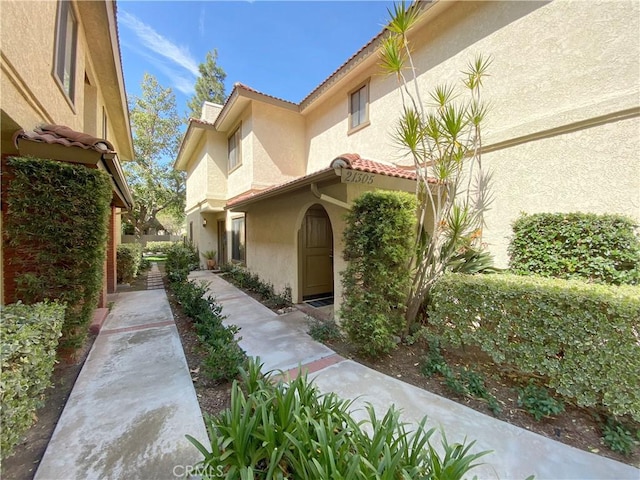 view of property exterior with a tiled roof and stucco siding