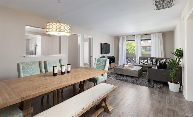 dining area with visible vents and wood finished floors