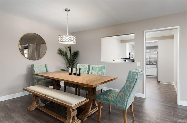 dining area featuring dark wood finished floors and baseboards