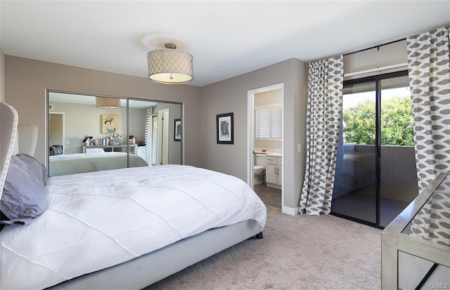 carpeted bedroom with ensuite bath, access to outside, baseboards, and a closet