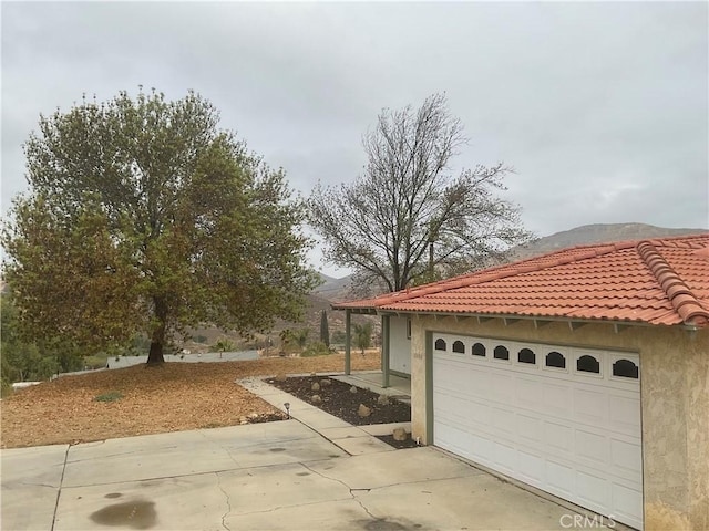 view of property exterior with a garage and a mountain view