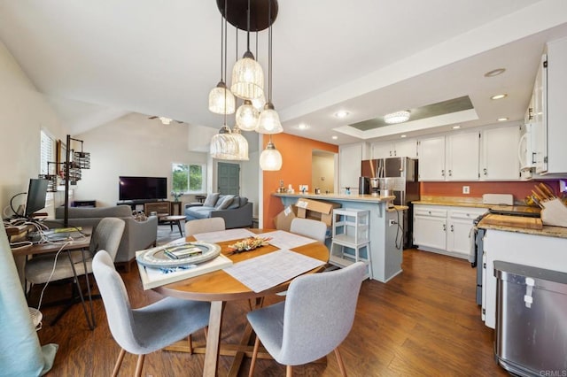 dining room with recessed lighting, dark wood-style flooring, a raised ceiling, and vaulted ceiling