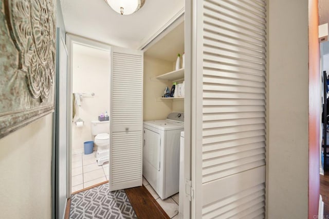 laundry room with laundry area, wood finished floors, and washing machine and clothes dryer