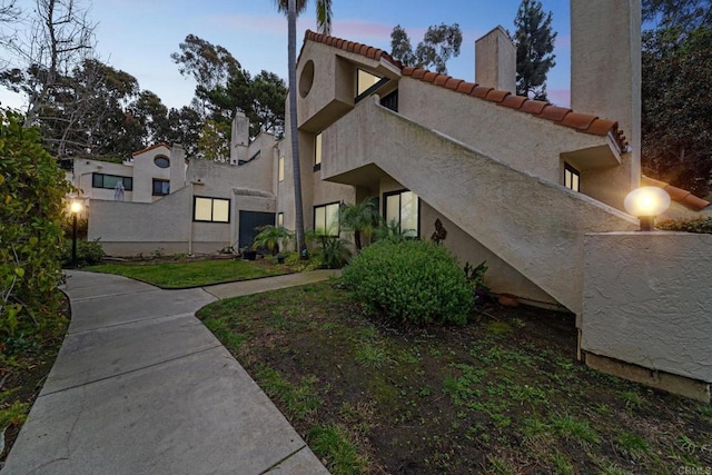 exterior space with a tiled roof and stucco siding