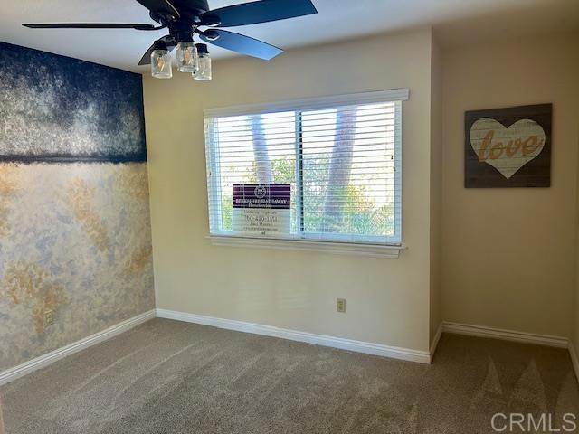 empty room featuring carpet flooring, ceiling fan, and baseboards