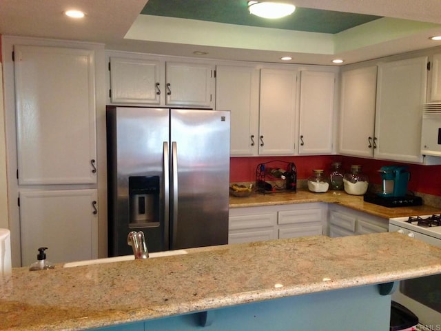 317 N Melrose Dr Unit E, Vista, CA 92083 - kitchen featuring white appliances, a raised ceiling, white cabinetry, recessed lighting, and light stone counters