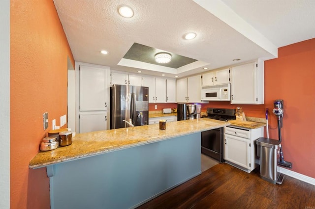 317 N Melrose Dr Unit E, Vista, CA 92083 - kitchen with stainless steel appliances, a peninsula, dark wood finished floors, white cabinets, and a textured ceiling