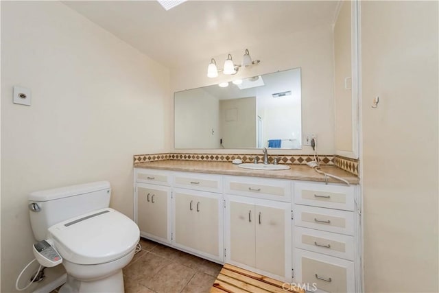 bathroom featuring tile patterned floors, vanity, toilet, and decorative backsplash