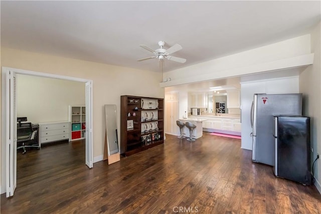 interior space with stainless steel refrigerator, ceiling fan, white cabinets, dark hardwood / wood-style flooring, and kitchen peninsula