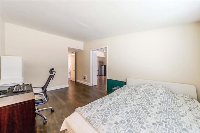 bedroom with dark hardwood / wood-style flooring and refrigerator