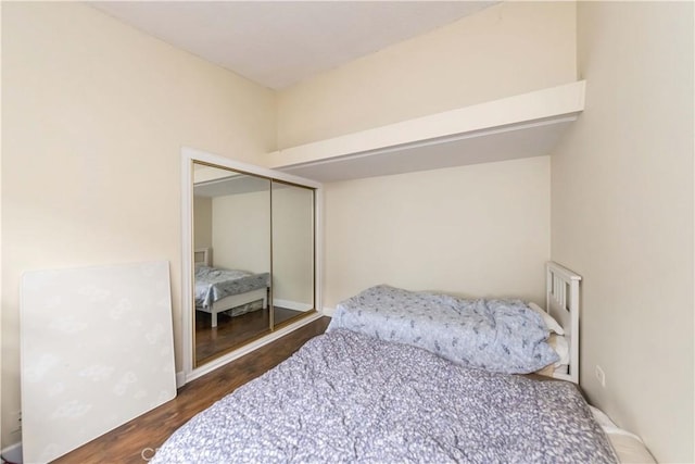 bedroom featuring dark hardwood / wood-style floors and a closet