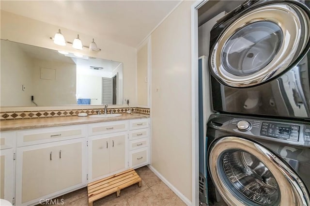 laundry area featuring sink, light tile patterned flooring, and stacked washing maching and dryer