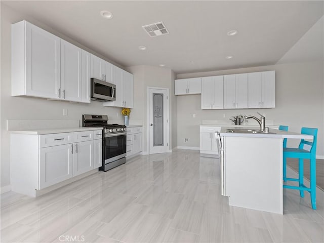 kitchen with a sink, light countertops, visible vents, and stainless steel appliances