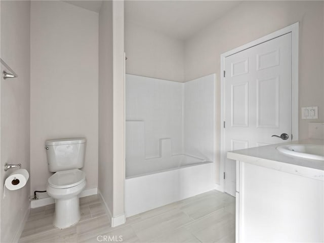 full bath with baseboards, vanity, toilet, and shower / bathtub combination