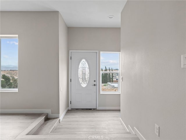 entrance foyer featuring light wood-type flooring and baseboards