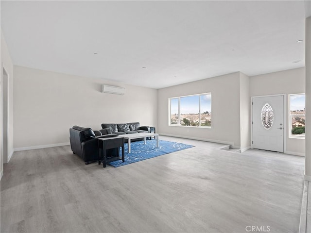 living area featuring a wall mounted AC, baseboards, and wood finished floors