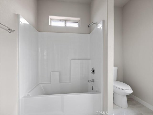 full bathroom with bathing tub / shower combination, toilet, and baseboards