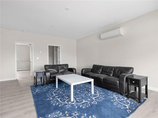 living room with an AC wall unit, wood finished floors, and baseboards