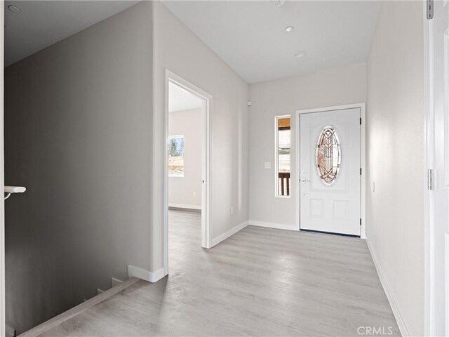 foyer entrance with light wood-type flooring and baseboards