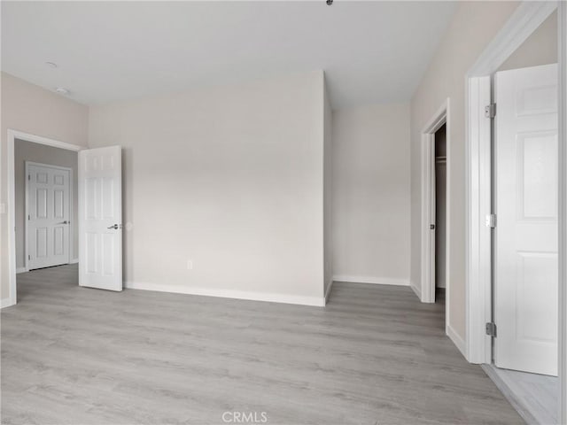 unfurnished bedroom with light wood-style flooring and baseboards