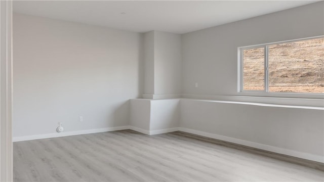 empty room featuring wood finished floors and baseboards