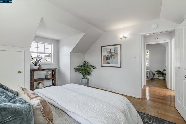 bedroom featuring vaulted ceiling and hardwood / wood-style floors