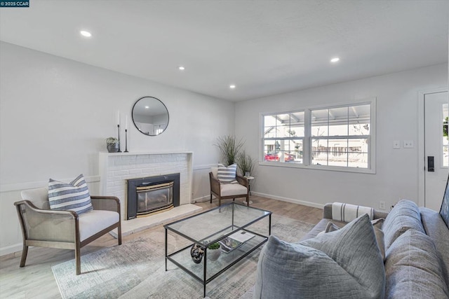 living room with a fireplace and light wood-type flooring