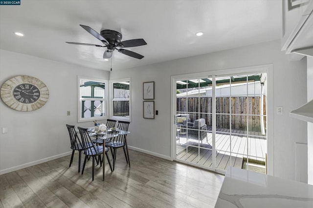 dining space with hardwood / wood-style floors and ceiling fan