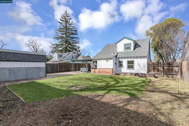 rear view of property featuring a storage unit and a lawn