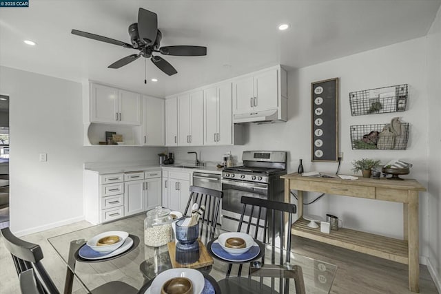 kitchen with dishwashing machine, sink, ceiling fan, stainless steel range with gas stovetop, and white cabinets