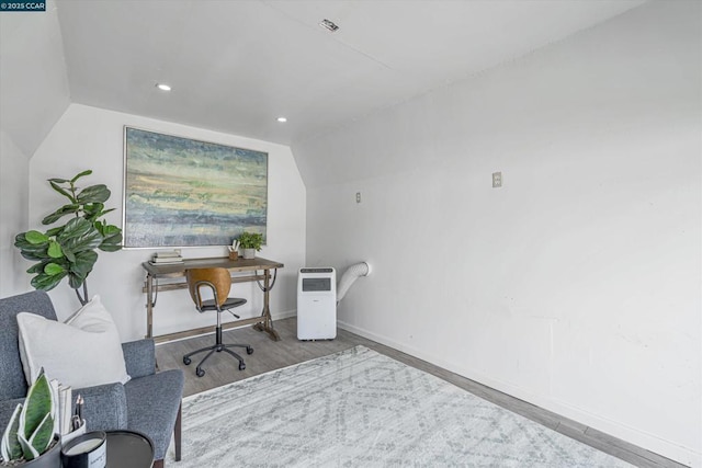 office space with vaulted ceiling and light hardwood / wood-style floors