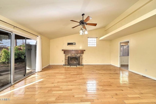 unfurnished living room featuring ceiling fan, a stone fireplace, lofted ceiling, and light wood-type flooring