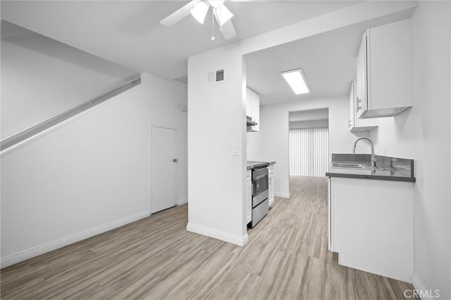 kitchen with sink, white cabinetry, stainless steel electric range, light wood-type flooring, and ceiling fan