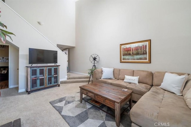 carpeted living room with a towering ceiling