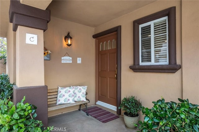 doorway to property featuring stucco siding