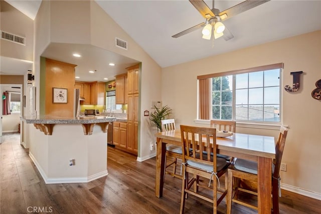 dining room with lofted ceiling, dark wood-type flooring, visible vents, and baseboards