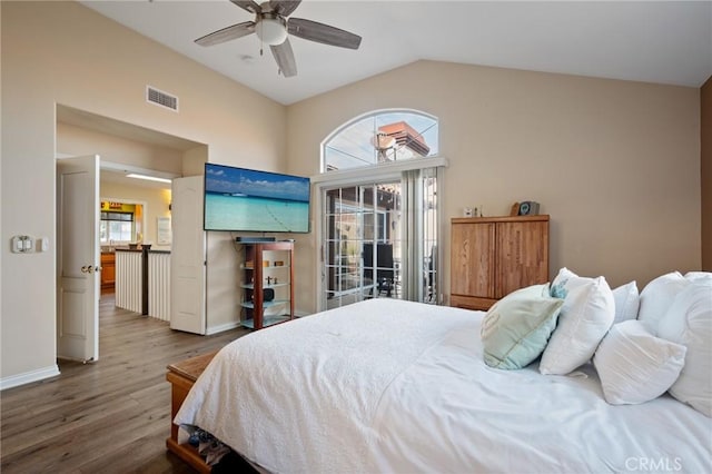 bedroom featuring lofted ceiling, multiple windows, wood finished floors, and visible vents